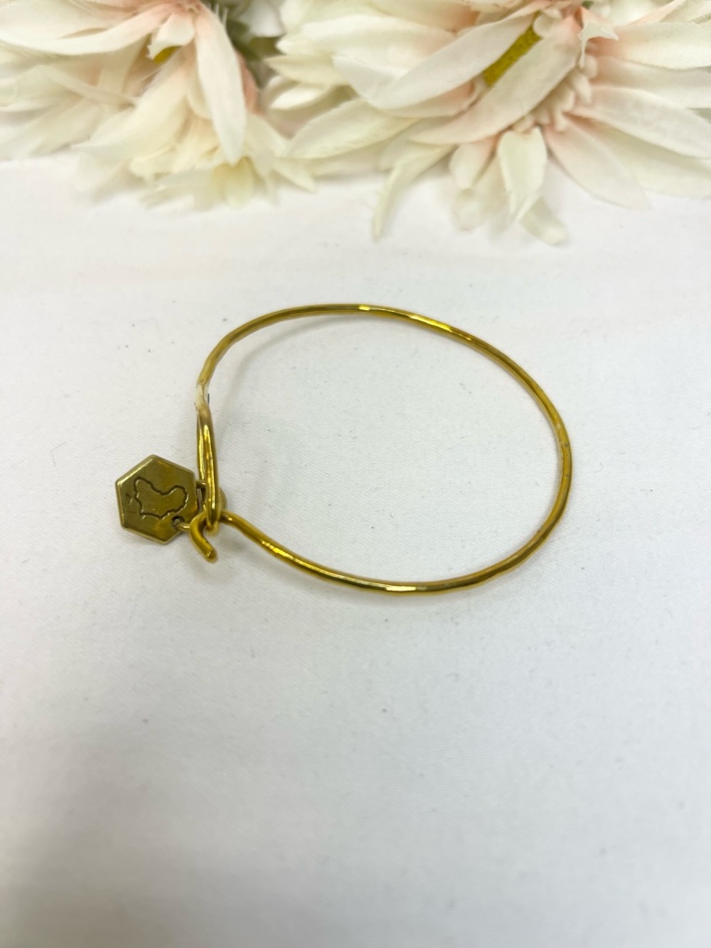 Sseko Gold Tone Hammered Wire Bracelet with Branded Hex Charm